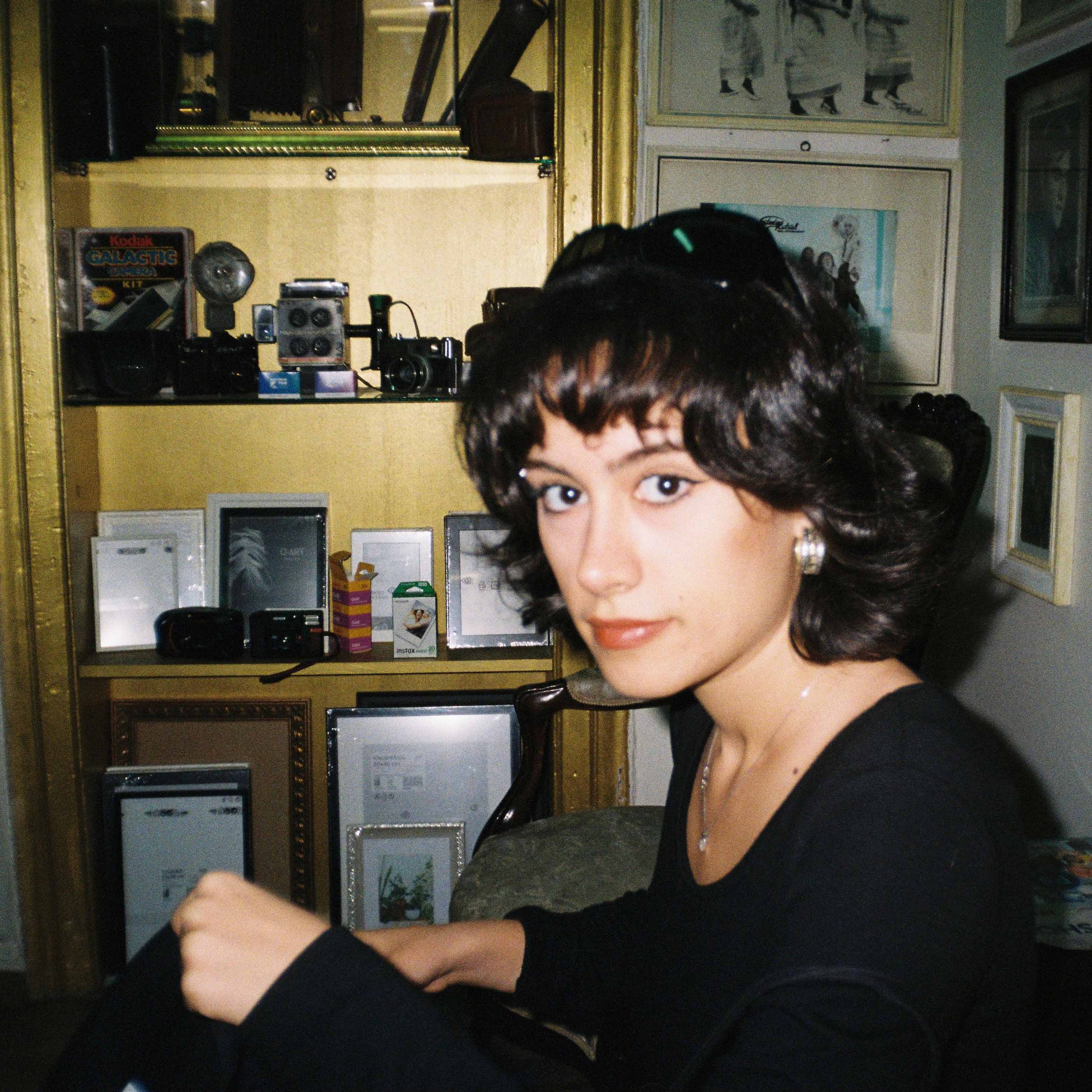 Cagla in a room looking at the camera.