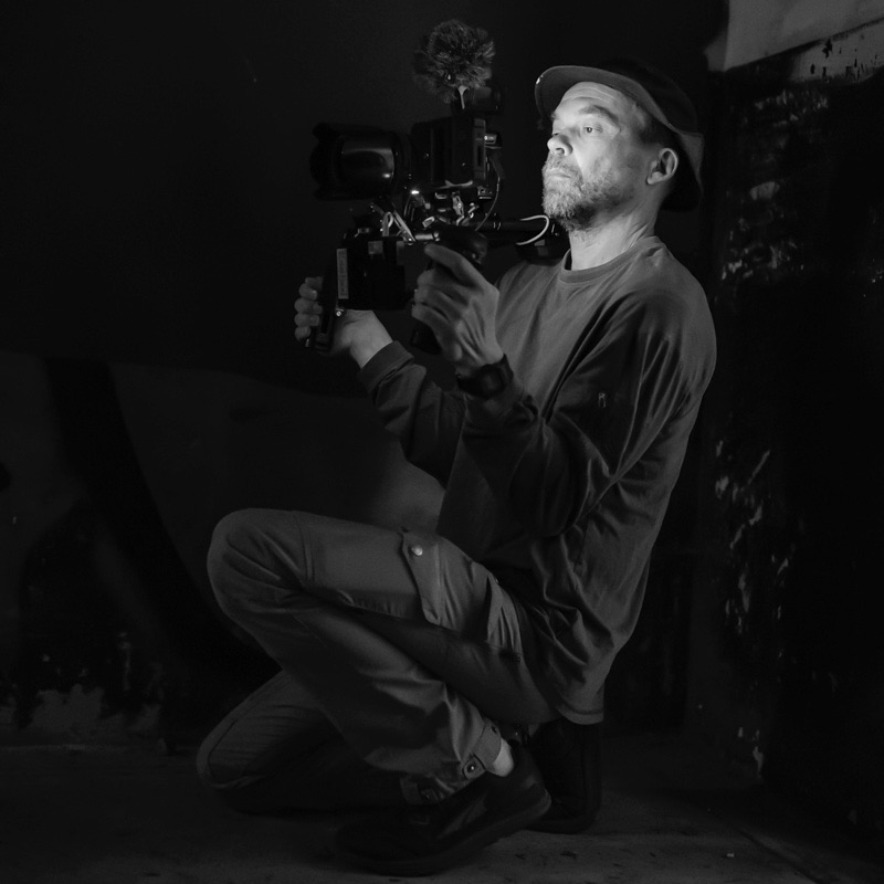 Dima filming in a black and white room.